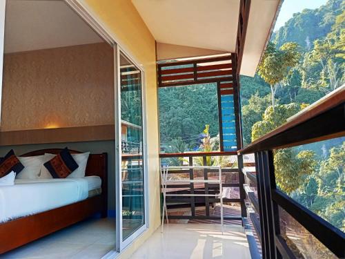 a bedroom with a bed and a balcony with a view at Chongkhao Resort- SHA Certified in Phi Phi Don