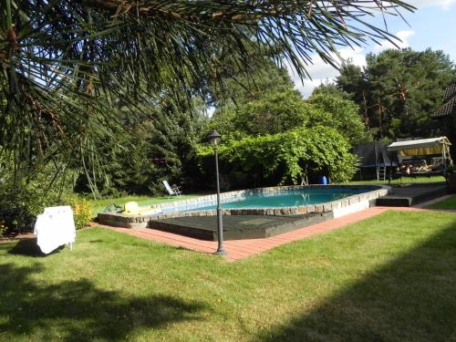 a swimming pool in a park with a light pole at DOM 4 POKOJE Z BASENEM BLISKO WARSZAWY in Józefów