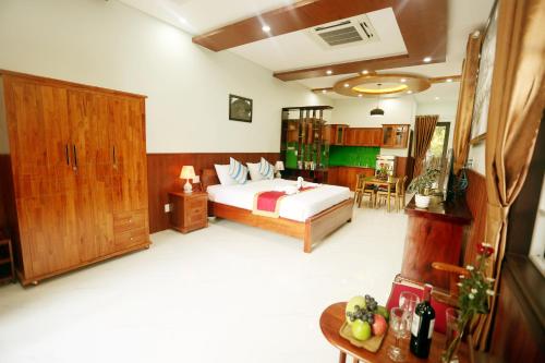 a bedroom with a bed and a table with fruits on the floor at Tan Doan An Bang center beach villas in An Bang