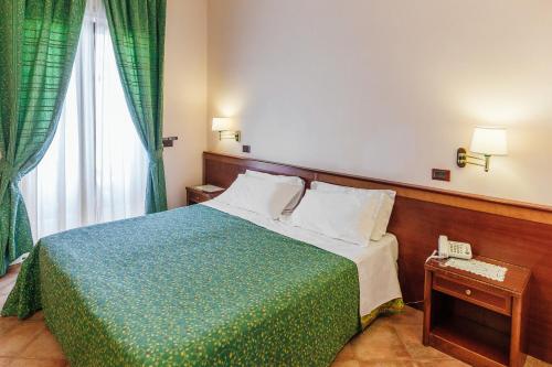 a bedroom with a bed and a phone and a window at Hotel Montana in Massa Lubrense