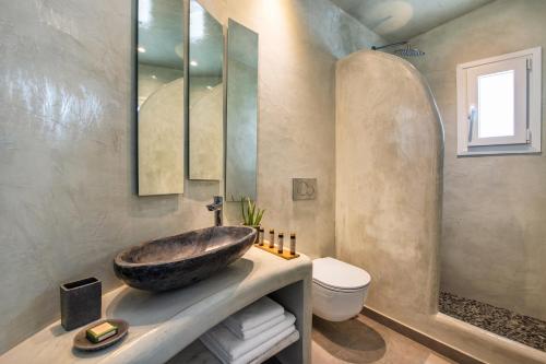 a bathroom with a sink and a toilet at Abasa Suites in Fira