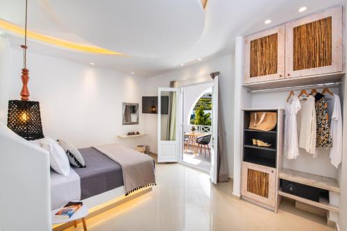 a bedroom with a bed and a door to a patio at Abasa Suites in Fira