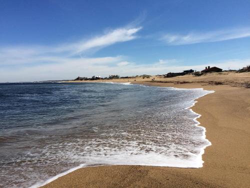a beach with the ocean and the shoreline at Posada Agua Marina in La Paloma