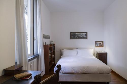 a bedroom with a white bed and a window at Cozy Family Apartment in Castelletto in Genova