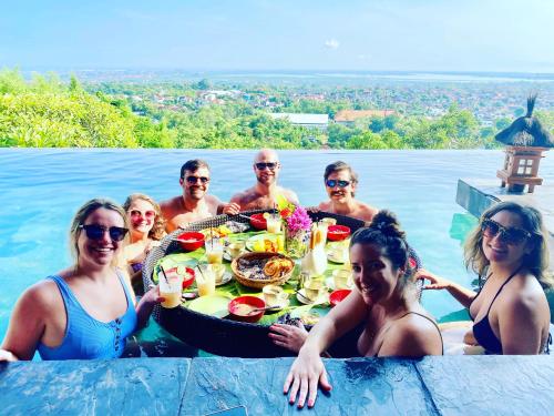 a group of people with a tray of food in the water at The Longhouse, Jimbaran - Bali in Jimbaran