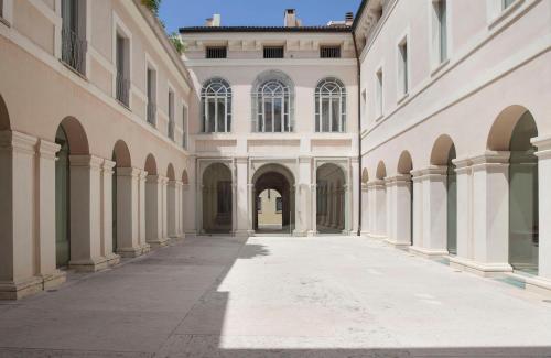 an empty alley between two large buildings with arches at PALAZZO BECCAGUTTI CAVRIANI - Gallery Suite e Frescoes Suite in Mantova