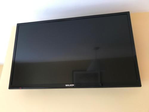 a flat screen tv hanging on a wall at Ashes Seafood Restaurant Accommodation in Dingle