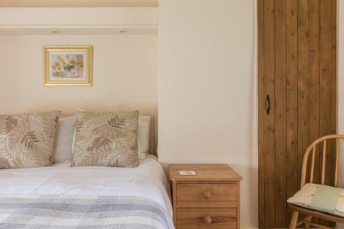 a bedroom with a bed and a wooden night stand at The Royal Oak in Gillamoor