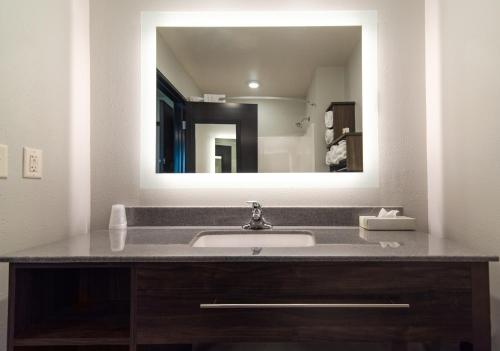 uma casa de banho com um lavatório e um espelho grande em My Place Hotel-Dahlgren/King George, VA em King George
