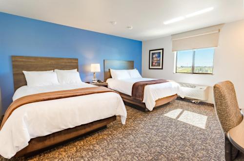 - une chambre avec 2 lits et un mur bleu dans l'établissement My Place Hotel-Dahlgren/King George, VA, à King George