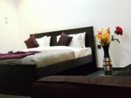 a bedroom with a bed with a vase of flowers at Taj Residence in Puttalam