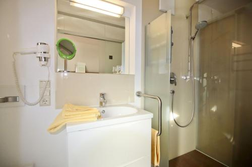 uma casa de banho com um lavatório e um chuveiro em Zeller Hof em Ruhpolding