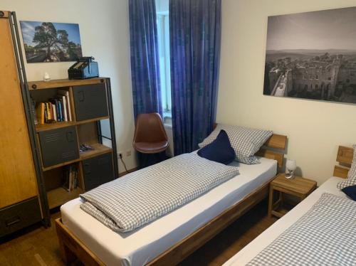 1 dormitorio con 2 camas y estante para libros en Doppelzimmer, en Bensheim