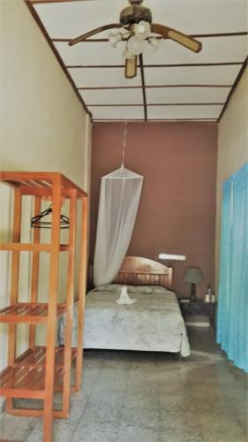 a bedroom with a ceiling fan and a bed at Hotel Tikal Inn in Tikal
