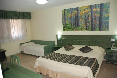 a hotel room with two beds and a painting on the wall at Albergo Ristorante Cacciatori in Auronzo di Cadore
