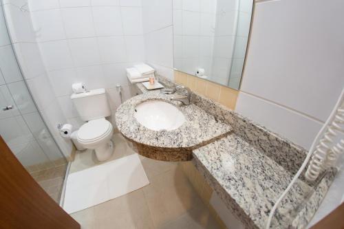 a bathroom with a sink and a toilet at Hotel Princess in Ponta Grossa
