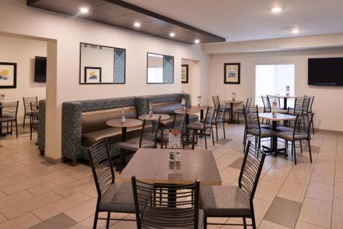 a restaurant with tables and chairs and a bar at Holiday Inn Express Hotel & Suites Sioux Falls At Empire Mall by IHG in Sioux Falls