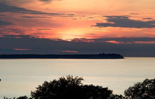 una puesta de sol sobre un gran cuerpo de agua en Ferienhaus Luette_, en Lohme