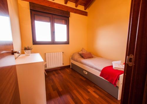 a small bedroom with a bed and a window at La Arcadia de Portillo in Portillo