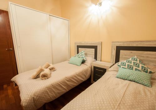 a bedroom with two beds and a large mirror at La Arcadia de Portillo in Portillo