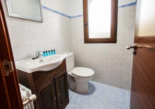 a bathroom with a white toilet and a sink at La Arcadia de Portillo in Portillo