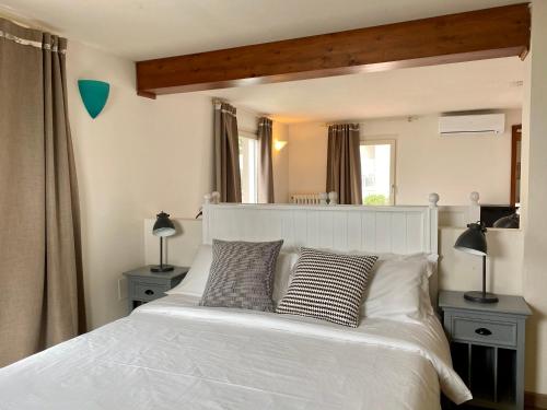 a bedroom with a large white bed with two lamps at Villa Pioppi Hotel in Sirmione