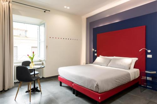 ein rotes und blaues Schlafzimmer mit einem Bett und einem Tisch in der Unterkunft Circle in the Square in Rom