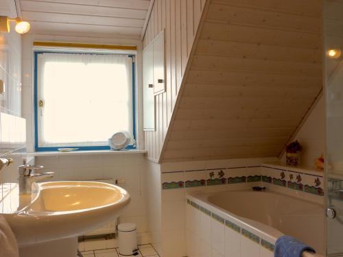 a bathroom with a sink and a bath tub at Historisches Kapitänshaus Breege in Breege