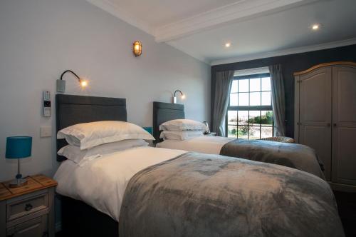 a bedroom with two beds and a window at The Plough Inn Ripple in Deal