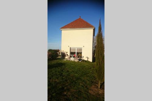 un grand bâtiment blanc avec un toit rouge dans l'établissement Le pigeonnier, à Chouzy-sur-Cisse