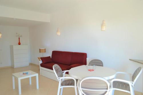 a living room with a white table and a red couch at Algamar by Garvetur in Vilamoura