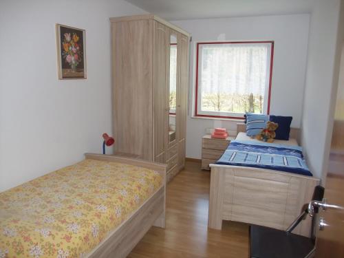 a bedroom with two beds and a cabinet and a window at Ferienhaus Hubertus in Elend mit Balkons in Elend