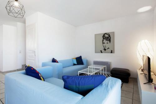 uma sala de estar com sofás azuis e uma televisão em Superb triplex with panoramic terrace - Bayonne - Welkeys em Baiona