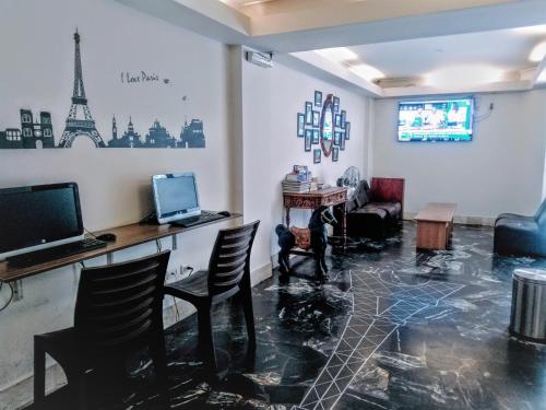 a living room with a table and chairs and a tv at Hotel Paris Lima in Lima