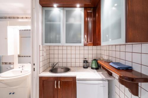 a small kitchen with wooden cabinets and a sink at Studio in the city center, Syntagma in Athens