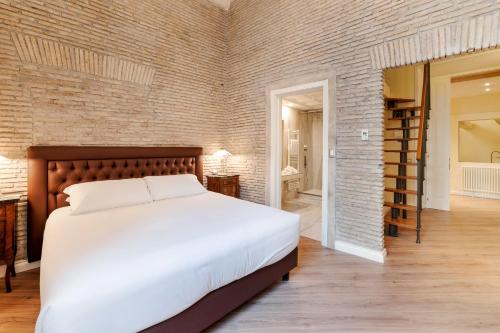 a bedroom with a large bed and a brick wall at Pantheon Hedonism in Rome