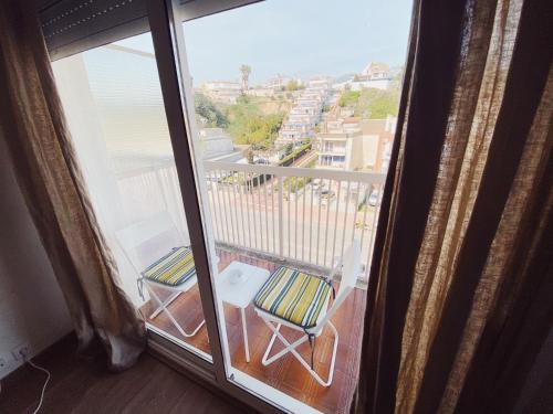 a balcony with a chair and a view of a city at Arena Gold Euroviajeros apartaments in Pineda de Mar