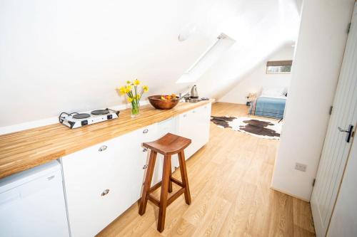 a kitchen with white cabinets and a wooden counter top at The Barn in Chichester