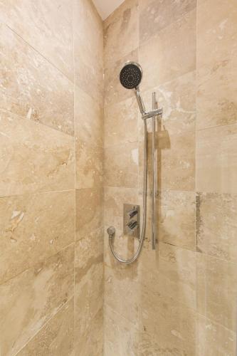 a shower with a shower head in a bathroom at The Hammock Lodge, Holborn, by the Design Traveller in London