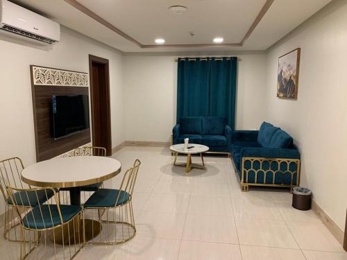 منازلنا للأجنحة الفندقية في جدة: غرفة معيشة مع أريكة وطاولة وكراسي