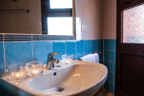 a bathroom with a sink with glasses on it at DomoMea - Villetta Poseidone in Costa Rei