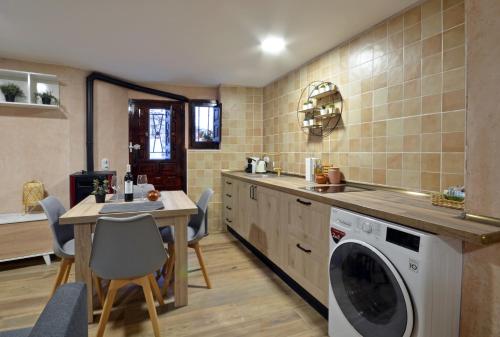 a kitchen with a washing machine and a table at PORTAL DE MOLINA 2 - Piso acogedor en el casco histórico de Albarracín in Albarracín