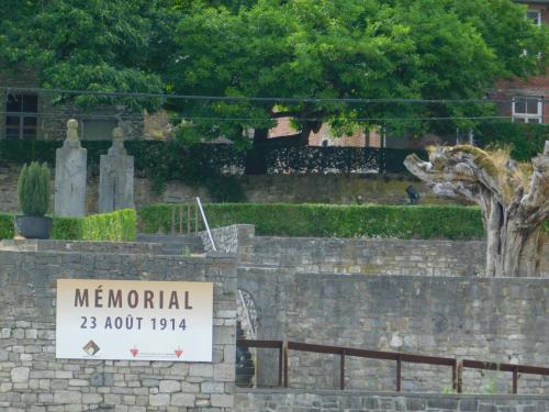 a sign in front of a stone wall with a cemetery at Les rives de Sax in Dinant