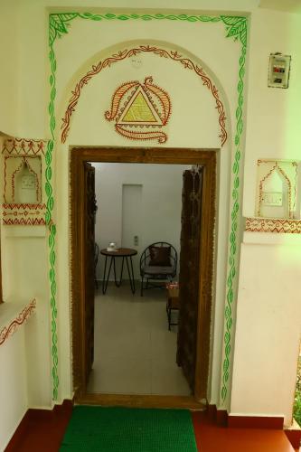 an open doorway into a room with a green rug at TOURIST VILLAGE KHAJURAHO in Khajurāho