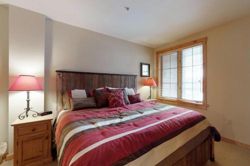 a bedroom with a large bed and a window at The Dakota Outpost in Keystone