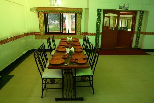 a long wooden table with chairs in a room at TOURIST VILLAGE KHAJURAHO in Khajurāho
