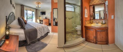 a bedroom with a bed and a bathroom with a shower at Hotel Santa Paula in Taxco de Alarcón