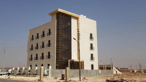 a large white building on the side of a street at Tunaib Plaza in Aţ Ţunayb
