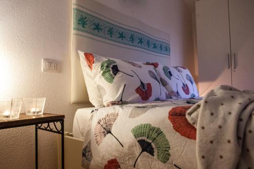 a bedroom with a bed with colorful pillows at DomoMea - Villetta Poseidone in Costa Rei