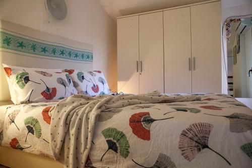 a bedroom with a bed with a blanket and pillows at DomoMea - Villetta Poseidone in Costa Rei